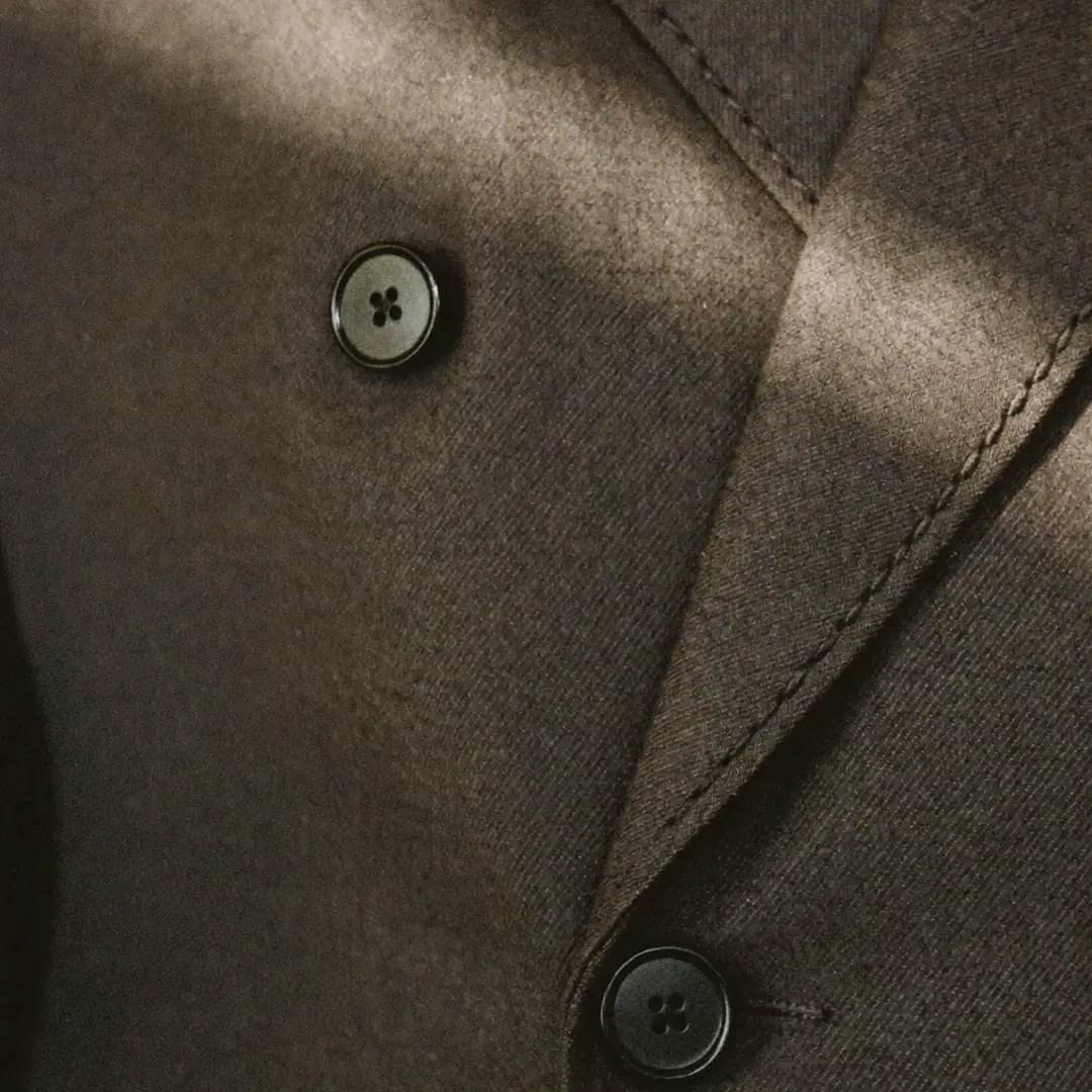 Buttons and pick stitching on woven wool